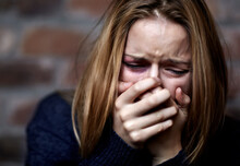 Emotionally Victimized. Abused Young Woman Crying Hard And Covering Her Mouth.