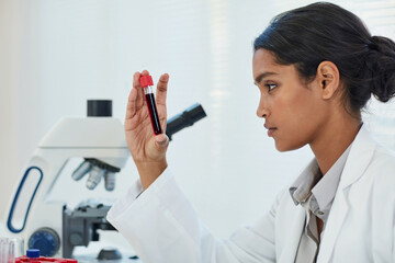 Determining the root cause of her latest medical case. Cropped shot of a young female scientist examining a test tube in a lab.