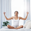 © Allistair F/peopleimages.com - Start your day on a peaceful note. Shot of an attractive young woman meditating while sitting on her bed in the morning.