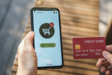 Poster - woman shopping online with credit card at coffee shop in outdoor.close up hand holding smartphone