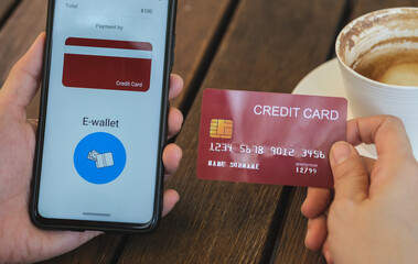 Poster - woman shopping online with credit card at coffee shop in outdoor.close up hand holding smartphone