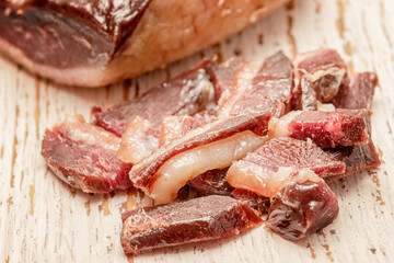 Meat, protein. A piece of dry-cured duck on an old board.