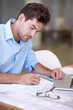 © M S/peopleimages.com - Vision and design. An attractive male architect focused on his work.
