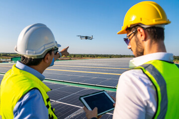 Wall Mural - professional engineer using drone and digital tablet maintaining solar cell panels together on build