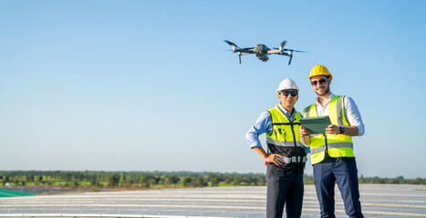 Wall Mural - professional engineer using drone and digital tablet maintaining solar cell panels together on build