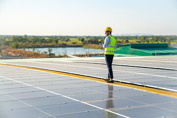 Wall Mural - professional man engineer using tablet maintaining solar cell panels on building rooftop. technician