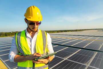 Wall Mural - professional man engineer using tablet maintaining solar cell panels on building rooftop. technician