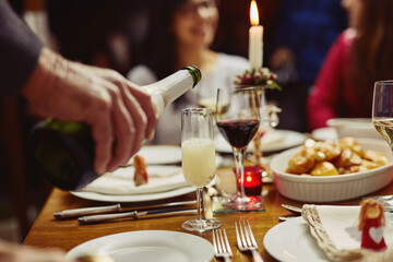 Wall Mural - This calls for a celebration. Closeup shot of a person pouring wine into a glass at a dining table.