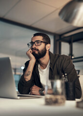 Aufkleber - Better finish up before I fall asleep. Shot of a young businessman looking uncertain while working late at night in a modern office.
