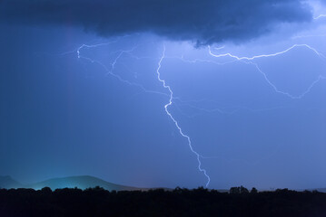 Wall Mural - View of lightning in blue sky at night. Extremadura, Spain.