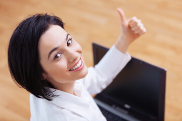 I give a big thumbs up to this laptop. High angle portrait of an attractive young woman showing thumbs up while using her laptop.