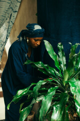 Wall Mural - Young African american woman fixing her plants outdoors