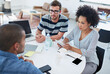 © Yuri A/peopleimages.com - Team dynamics. Shot of coworkers talking over a digital tablet.