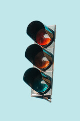 Sticker - Close-up shot of a metal traffic light against blue sky in bright sunlight outdoors