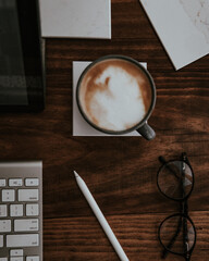 Canvas Print - Top view of mug of Nescafe with computer and pen on a table