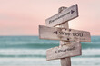 remember why you started text quote written on wooden signpost by the sea. Positive pink turqoise pastel theme.