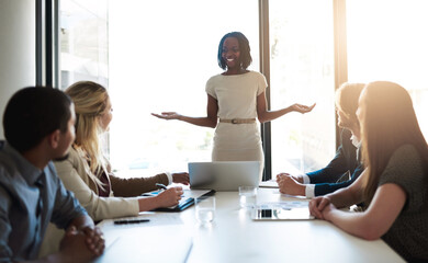 Poster - Shes got their full attention. Shot of a young businesswoman leading her team in a meeting in the office.