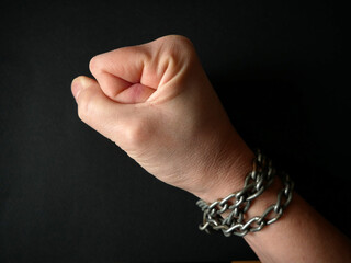 hands clenched into fists in handcuffs in the form of chains on a black background, the problem of slavery and violence concept, juneteenth Freedom Breaking Chains