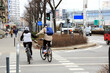 Para ludzi jedzie na rowerach, trzymając się za ręce ulicami Wrocławia.	