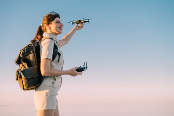 Drone launch. Young woman tourist holds a drone in his hand lifting it up.