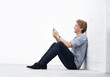 © Anne B/peopleimages.com - Sending an sms. A young man sitting in the studio and using his cellphone.