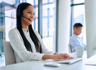 Poster - If it needs fixing, Ill find a way. Shot of a young woman using a headset and computer in a modern office.