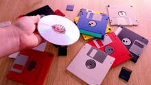 Vintage Retro Electronic Data Storage Devices From The 80s, 90s, Cd Disk, Flash Drives Scattered On Table. Stack Of Floppy Disks, Pendrive And Hard Disk In Grey, Black, Blue, Yellow, Red, White