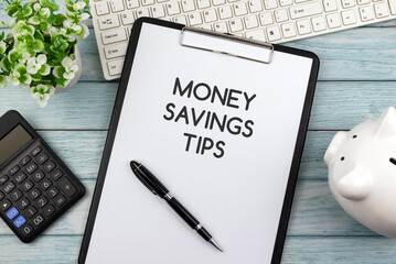 Wall Mural - Money savings tips text on clipboard, piggy bank, calculator and computer keyboard