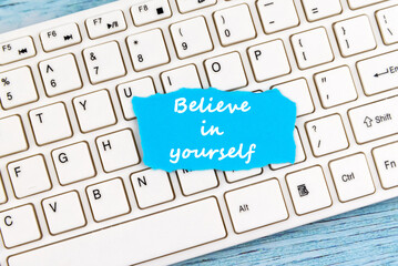 Wall Mural - Inspirational quotes - Believe in yourself on a torn paper on top of computer keyboard