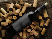 Close-up. A Bottle Of Wine Lies On Wine Corks On A Wooden Background. Hotel, Restaurant, Wine Cellar, Winemaking. Collectible Wines, Advertising, Banner, Poster.