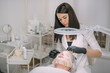 © Anna - Cosmetologist and dermatologist makes a moisturizing, rejuvenating woman lying patient in a beauty salon.