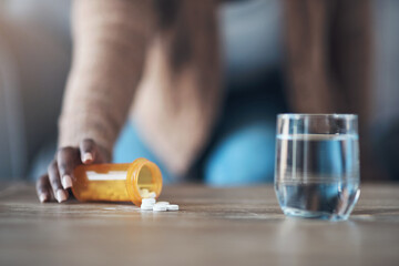 Poster - Time for my dose of painkillers. Cropped shot of an unrecognizable woman sitting alone and taking pills out of a pill bottle in her living room.