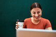 © Chanelle M/peopleimages.com - Coffee gets me through the busy day. Cropped shot of an attractive young businesswoman sitting alone and using her laptop while holding a cup of coffee.