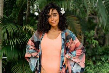 Close up portrait of  smiling woman with  plumeria flower in hairs after spa in   luxury resort. Wearing boho tropical outfit.