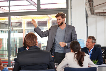 Poster - Presenting his ideas. Cropped shot of a businessman addressing his colleagues during a meeting.