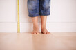 © M S/peopleimages.com - Getting taller by the day. Cropped shot of a young boy standing next to a tape measure.
