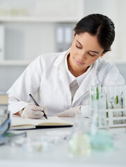 Poster - Working on a new theory of hers. Shot of a young scientist writing notes while working in a lab.