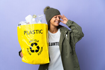 Wall Mural - Young woman holding a bag full of plastic smiling a lot