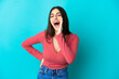© luismolinero - Young caucasian woman isolated on blue background shouting with mouth wide open