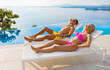 © Kaspars Grinvalds - Couple sunbathing by the pool of luxury Mediterranean hotel