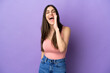 © luismolinero - Young caucasian woman isolated on purple background shouting with mouth wide open