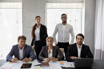 Poster - Group portrait of five confident serious diverse business people employees managers of different ages in formal wear posing together in modern workplace, professional career, teamwork concept.