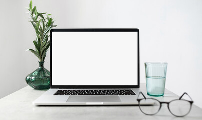 Laptop computer with empty blank mockup screen over white modern living room design. Home office, workplace, working or studying from home, distance learning, business concept