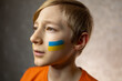 © Roman - a child against war, a portrait of a boy with a painted flag of Ukraine on his cheeks proudly looks away