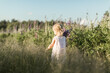 a child walks in a field with a bouquet of flowers