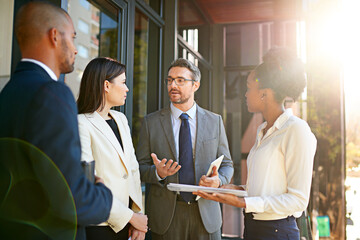 Poster - If we work together, well make a success of this. Shot of a diverse group of businesspeople having a meeting on a balcony in bright sunlight.
