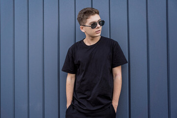 Portrait of a fashion young man leaning against a blue wall