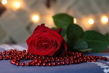 Red Rosebud, Red Beads And Light In The Background. International Rose Day - 21 May