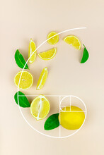 Fresh Slices Of Yellow Lemon Lime Fruit With Green Leaf And Ice Cube Laid Out On A Pastel Background In The Form Of Golden Ratio.