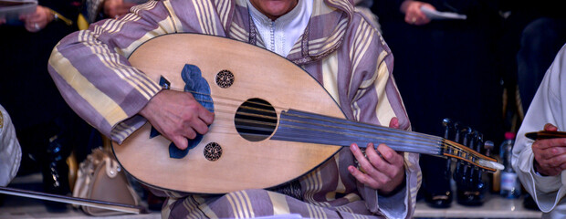 Wall Mural - A Moroccan player wearing a djellaba plays the oud